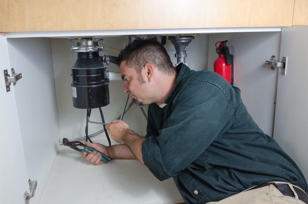 man fixing their houme's plumbing system