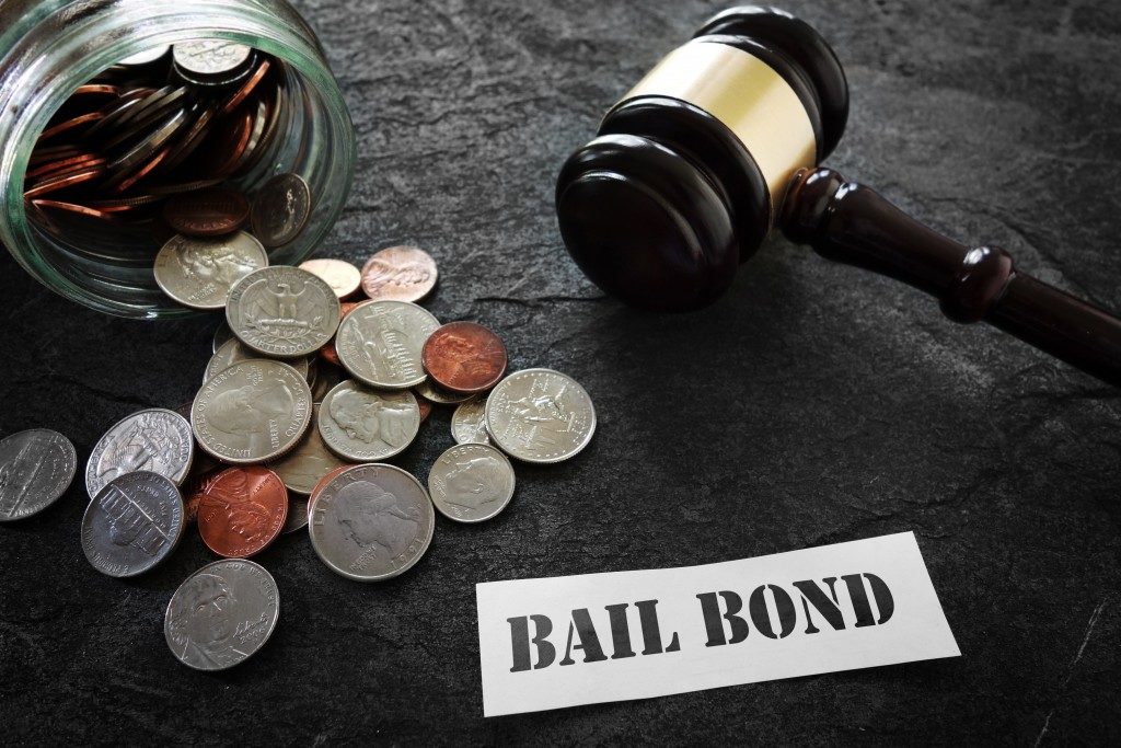 coins gavel and bail bond on paper