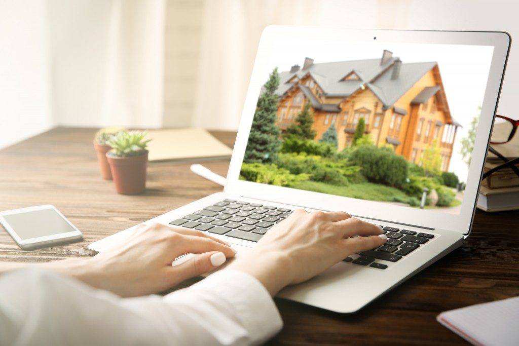 woman looking at a house on the laptop