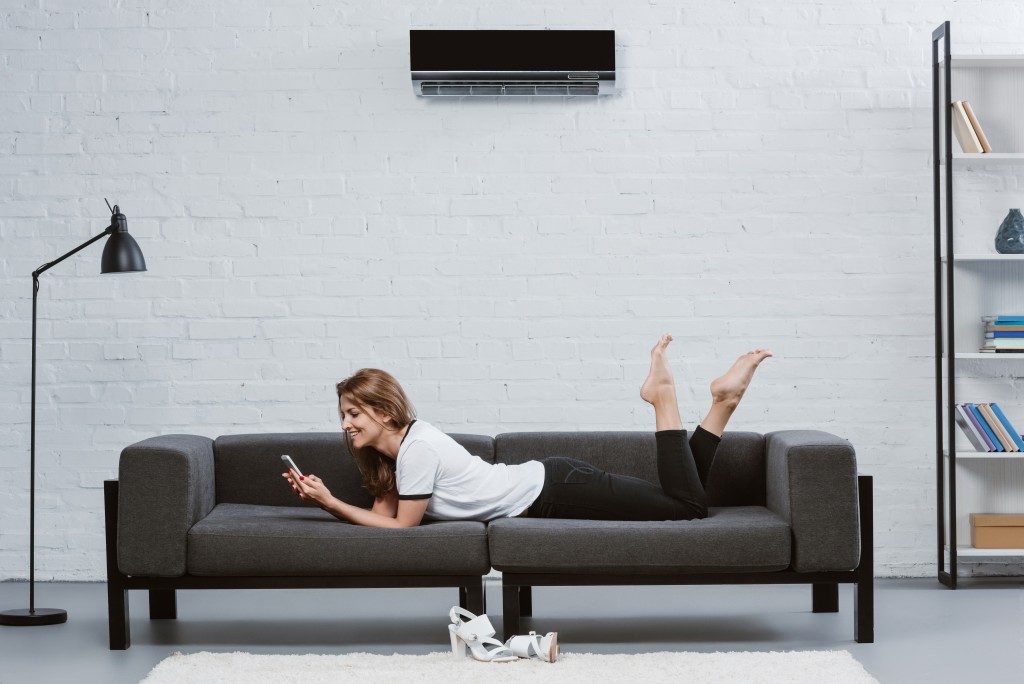 woman laying on the couch with her phone