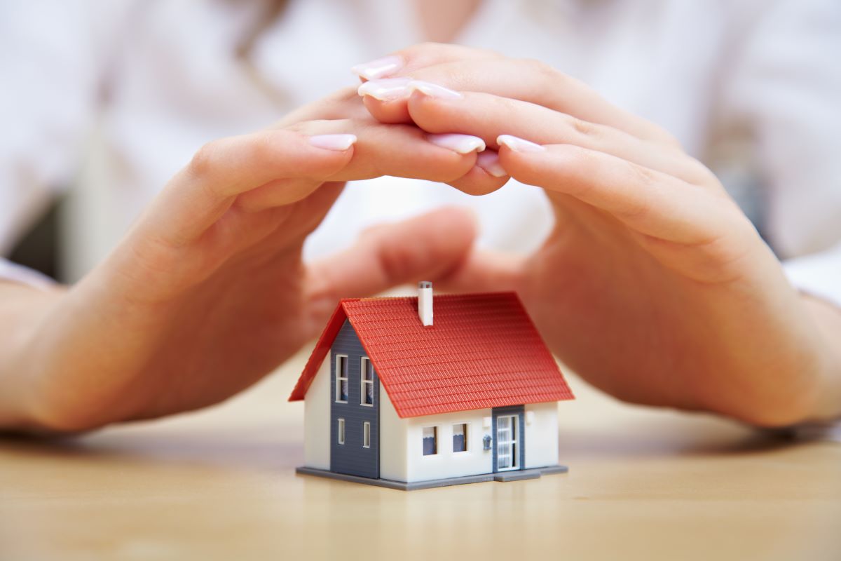 hands hovering above a tiny house model