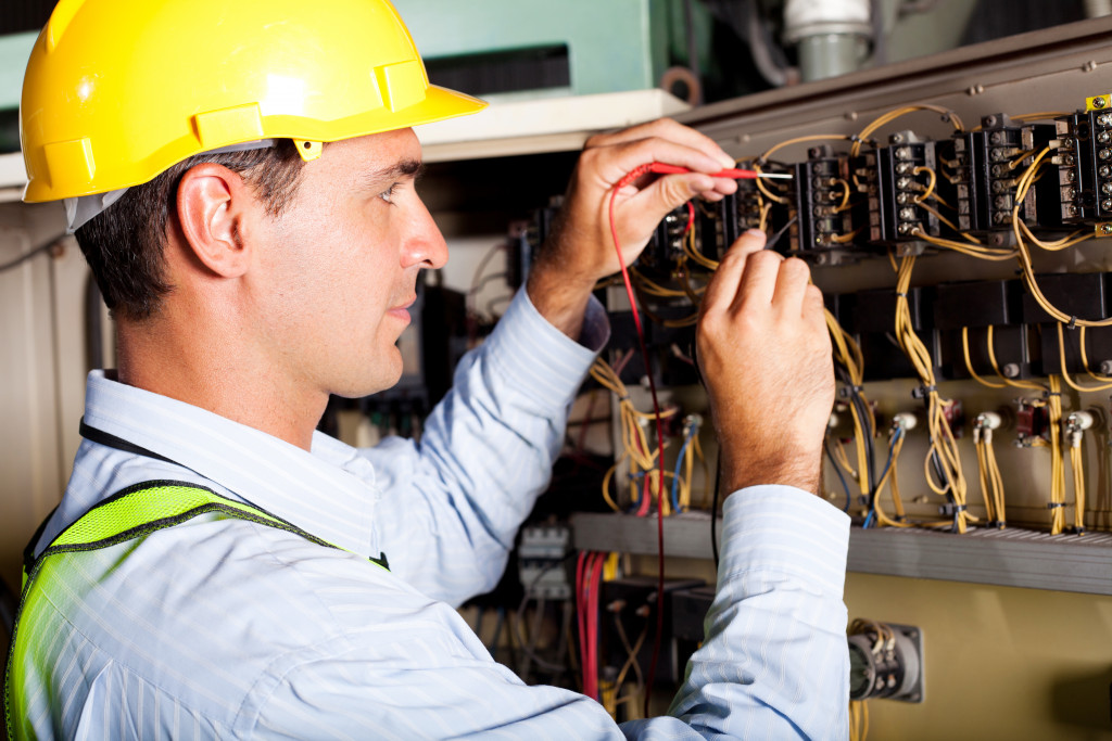 man repairing the wires inside a fuse box
