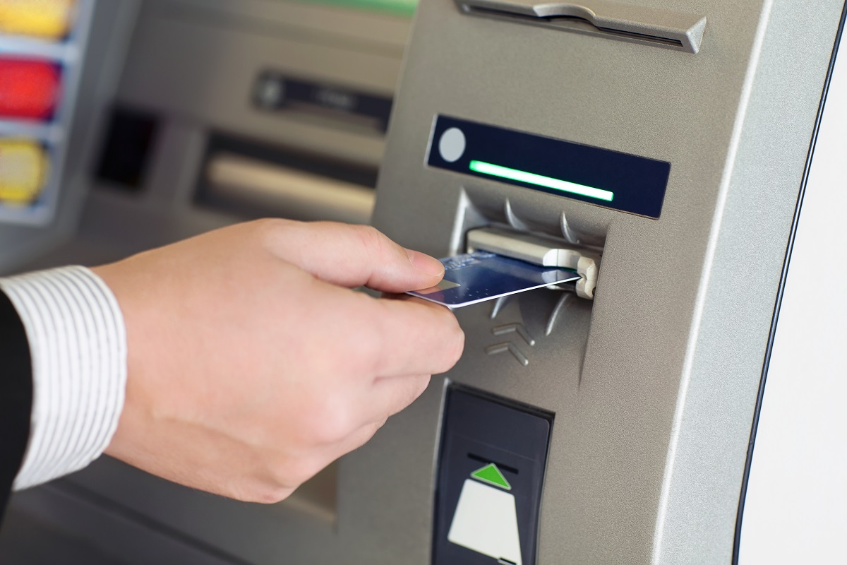 man inserting card at the ATM machine